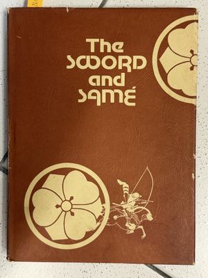 the sword and the same book on a table with a pair of scissors