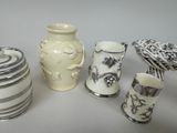 five different vases and a bird sitting on a table