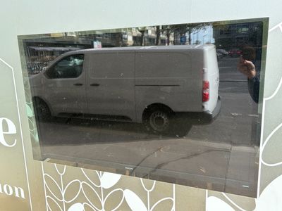 le reflet d'une camionnette dans la vitrine d'un magasin