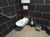 a toilet and a trash can in a public restroom