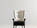 a black and white chair in a white room with a white wall