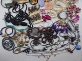 a pile of assorted necklaces and bracelets on a table