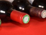 several bottles of wine are lined up on a red surface