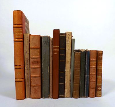 several old books are stacked on top of each other on a white surface