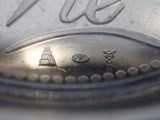 a close up of a silver plate with a silver spoon in it