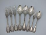 six silverplated spoons and six forks on a white surface