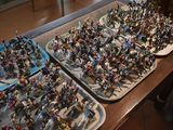 several trays of miniature figurines are on a table