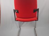 a red chair that is sitting on a metal frame