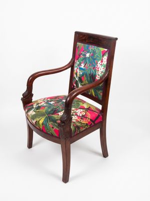 un gros plan d'une chaise en bois dont l'assise est recouverte d'un tissu coloré