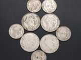 six types différents de pièces d'argent sur une surface noire