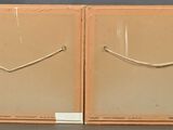 pair of framed art pieces of a smiling face on a shelf