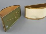 pair of green and white boxes with gold trims on a gray surface