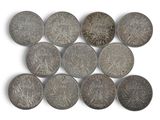 several old coins are arranged in a row on a white surface