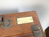 a small wooden box with a metal latch on top of it