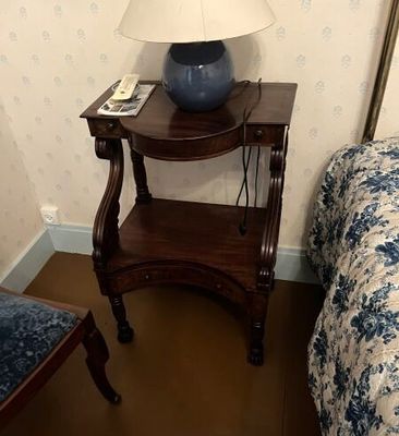 une petite table sur laquelle est posée une lampe, à côté d'un lit
