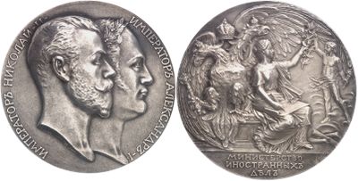 two silver medals with a man and a woman on them