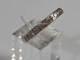 an image of a diamond wedding band on a clear block