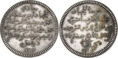 two silver coins with arabic writing on them