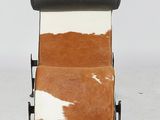 a brown and white cowhide lounge chair with black leather seat
