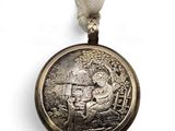 a silver medal with a silver ribbon around it