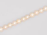 un gros plan d'un collier de perles sur fond blanc