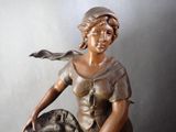 statue of a woman sitting on a horse with a hat on her head