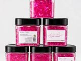 six pots de paillettes roses avec des couvercles noirs et des couvercles noirs