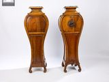 pair of tall wooden vases with a lion head on the top