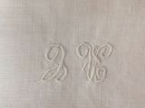 a close up of a white towel with two initials on it