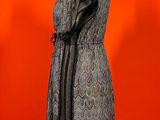 an image of a dress on a mannequin stand against a red background