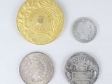 four different types of silver and gold coins on a white surface