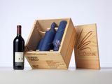 a bottle of wine next to a wooden box with a bottle of wine in it