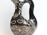 a black and white vase on a white surface
