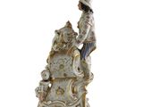 a figurine of a woman sitting on top of a chair