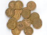 quelques pièces d'or empilées les unes sur les autres sur une surface blanche