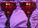 une paire de verres à vin rouge dans une boîte violette, posée sur un tissu violet