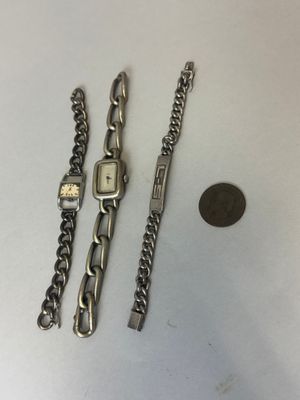 deux montres et une pièce de monnaie posées sur une table à côté d'un penny