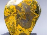 an image of a yellow and black stone sculpture on a black base