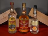 three bottles of liquor sitting on a table next to a wooden box