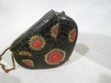 un sac à main noir orné de fleurs dorées et rouges