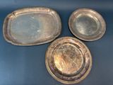 three silver trays sitting on top of a table next to each other