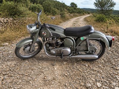 une moto garée sur le bord d'un chemin de terre