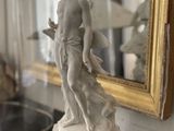 a statue of a man and a dog on a table in front of a mirror