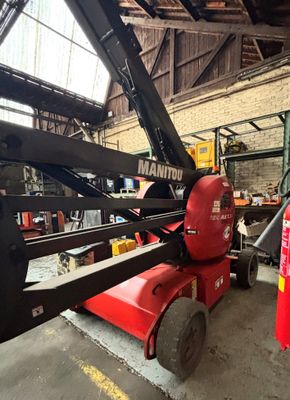 un chariot élévateur dans un entrepôt, avec une borne d'incendie rouge en arrière-plan