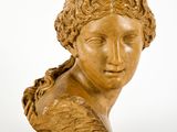 un gros plan d'une sculpture représentant une tête de femme posée sur un socle en marbre
