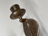 a bronze statue of a hat and a feather on the wall