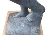 statue of a person standing on a rock with their feet on the ground