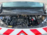 une voiture dont le capot est ouvert et dont le moteur se trouve dans le coffre
