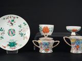 trois tasses, une soucoupe et une assiette posées sur une table