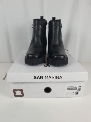 a pair of black ankle boots sitting on top of a white box